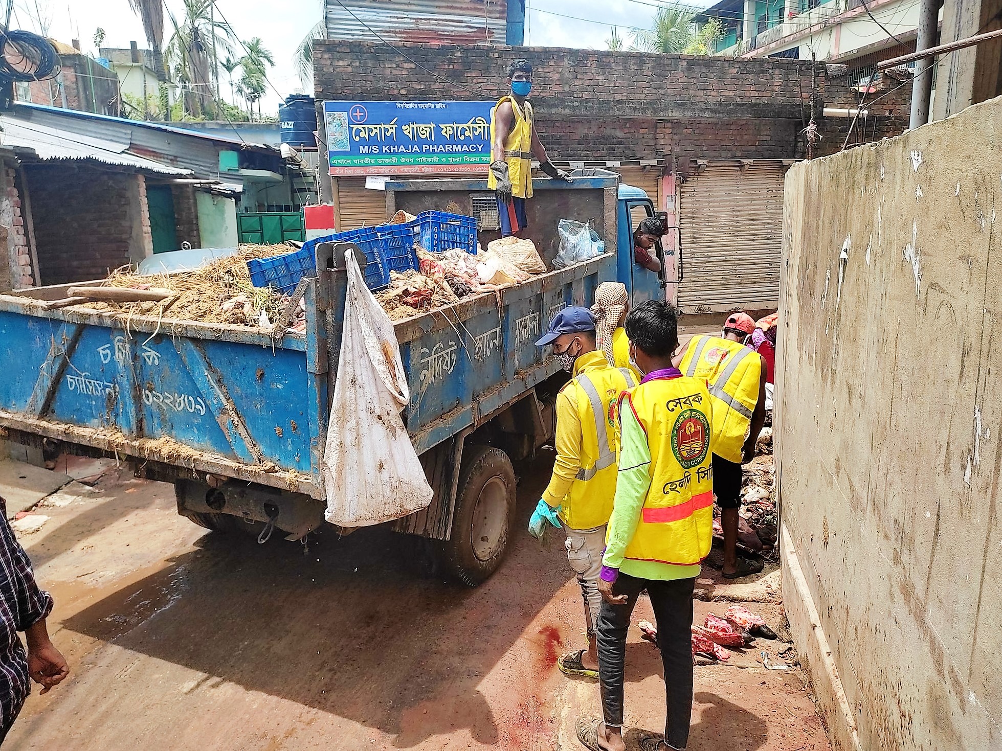 কোরবানির বর্জ্য অপসারণে ব্যস্ত সেবকরা কোরবানির বর্জ্য অপসারণে ব্যস্ত সেবকরা